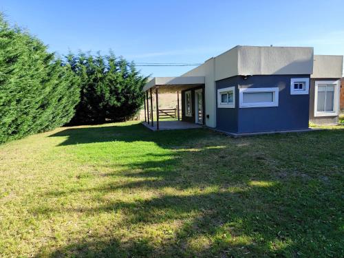 una piccola casa blu su un cortile erboso di Luluk, Casa de playa a Balneario Pehuén-Có
