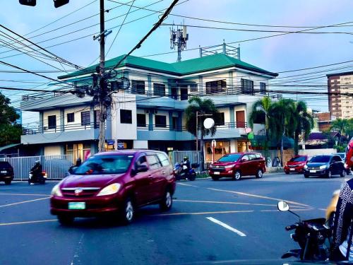 Ein rotes Auto fährt die Straße entlang vor einem Haus in der Unterkunft Cranberry's 3 br Apartment nr Convention Ctr #4 in Iloilo City