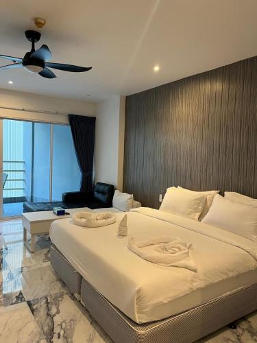 a bedroom with a large bed and a living room at View Talay 6 Pattaya in Pattaya
