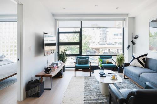a living room with a couch and a table at Stylish Williamsburg One Bedroom Condo Near Manhattan in Brooklyn
