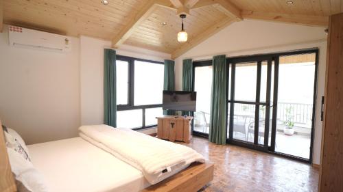 een slaapkamer met een bed en grote ramen bij Amber Moon in Dagshai