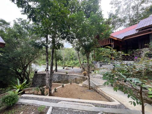 een tuin met een vijver voor een gebouw bij Guesthouse Hidden Corner Batu Katak in Timbanglawang