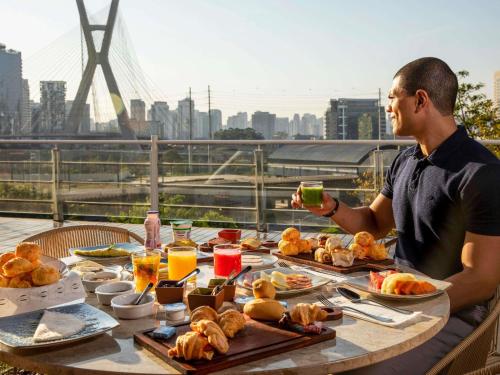 um homem sentado à mesa com comida em Novotel Sao Paulo Morumbi em São Paulo