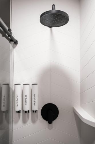 a bathroom with a shower with a light and a sink at The Amaya - 21 and older only in Fort Wayne