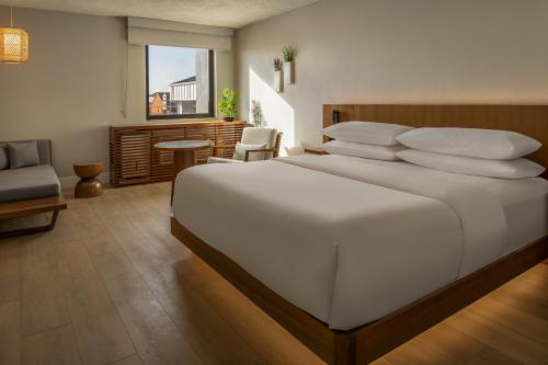 a bedroom with a large white bed with pillows at The Amaya - 21 and older only in Fort Wayne