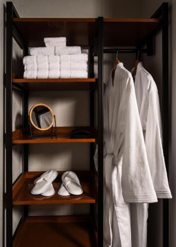 a closet with white towels and white shoes at The Amaya - 21 and older only in Fort Wayne