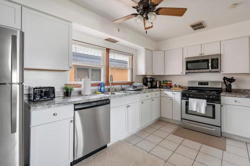 een keuken met witte kasten en een plafondventilator bij Executive Retreat - 2 Parking Spaces, Sleeps 4! in Westmont