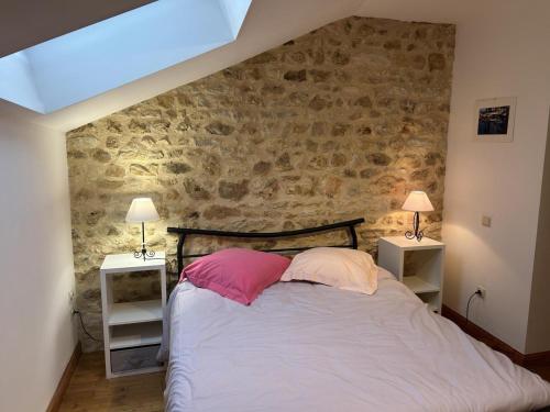 a bedroom with a bed with two pink pillows at Gîte de Charme avec Jardin, Wifi et Parking à Saint-Gourson - FR-1-653-285 in Saint-Gourson