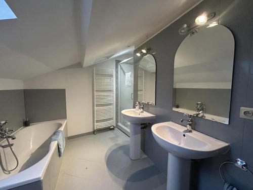 a bathroom with two sinks and a tub and mirrors at Gîte de Charme avec Jardin, Wifi et Parking à Saint-Gourson - FR-1-653-285 in Saint-Gourson