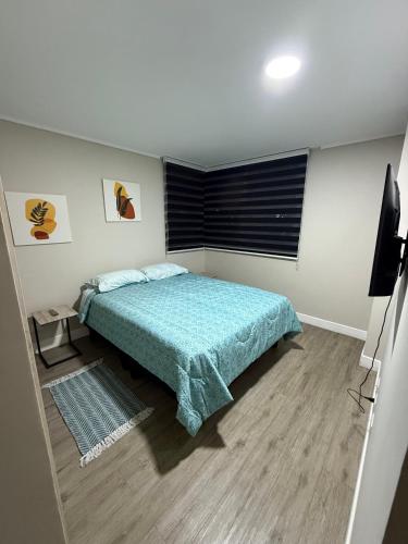 a bedroom with a bed and a television in it at Departamento con vista a coquimbo y bahía in Coquimbo