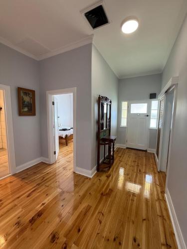 an empty living room with a hard wood floor at Recently renovated, spacious 3 bedroom home in Port Pirie