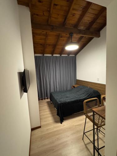 a bedroom with a bed and a table in a room at Colonial suites in San Bernardo