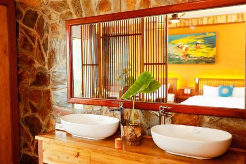 a bathroom with two sinks on a wooden counter with a mirror at Diều Sóc Sơn in Sóc Sơn
