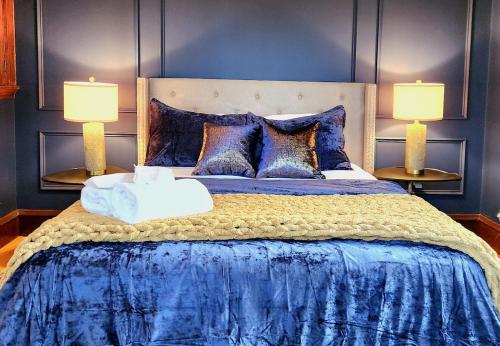 een slaapkamer met een blauw bed en 2 lampen bij Prestigious Milton Designer Home in Milton