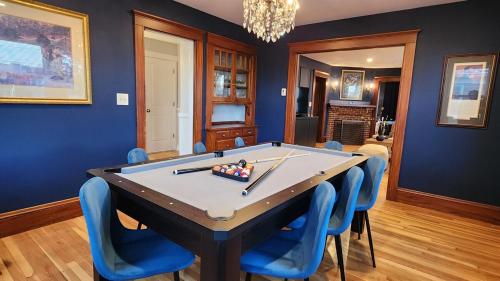 een eetkamer met een pooltafel en blauwe stoelen bij Prestigious Milton Designer Home in Milton