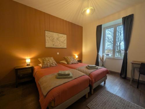 a bedroom with a bed with two towels on it at Les champs dessus in Sarrey
