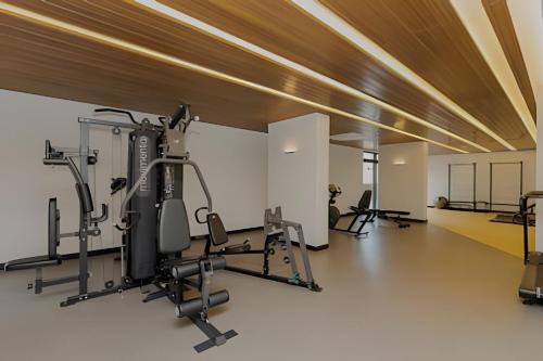 ein Fitnessstudio mit mehreren Laufbändern und Geräten in einem Raum in der Unterkunft Essenza Elysia Premium Studio in Curitiba