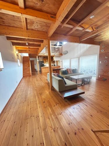 a living room with wooden floors and a couch at Ajito Niseko in Kutchan