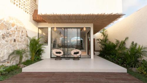 a house with two chairs on a patio at Casa Amani 3BR Mediterranean w Pool Near Seminyak in Kerobokan