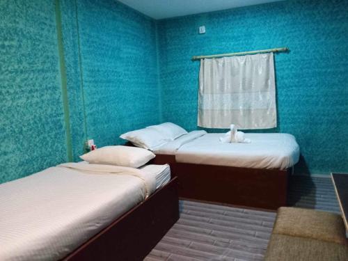 duas camas de solteiro em um quarto com paredes azuis em Rhino Spot Resort em Meghauli