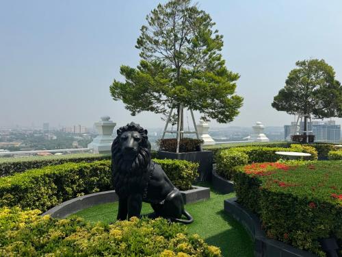 Sky Pool Apartment Hotel Near the Beach في جومتين بيتش: تمثال الاسد جالس في حديقه