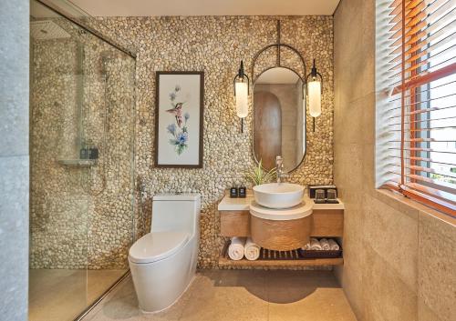 Un baño con inodoro, lavabo y espejo. en Swiss-Belvillas Solavita Binh Tien, en Binh Tien