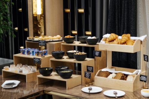 une présentation de différents types de pains et de pâtisseries sur des boîtes dans l'établissement AD Bellagio, à Samarcande