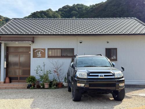 a black truck parked in front of a house at ゲストハウス道 Michi in Nachikatsuura
