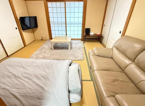 a living room with a couch and a table at ゲストハウス道 Michi in Nachikatsuura
