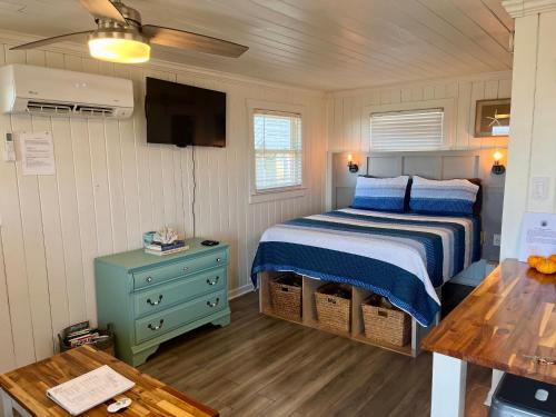 een slaapkamer met een bed, een tv en een tafel bij Egret in Holden Beach