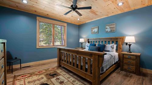 Luxe Lakefront Retreat w Pool Hot Tub Theater Private Dock Sleeps 20 في ليك نورمان أوف كاتاوبا: غرفة نوم بسرير خشبي مع جدران وسقف باللون الأزرق