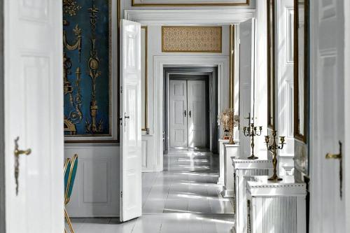 a hallway with white walls and a blue and white wall at Manor With Soul Between Forest And Lake On Funen in Ullerslev