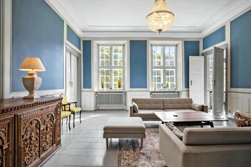 a living room with blue walls and a couch at Manor With Soul Between Forest And Lake On Funen in Ullerslev