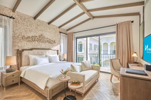 una habitación de hotel con una cama y un escritorio en Swiss-Belvillas Solavita Binh Tien, en Binh Tien