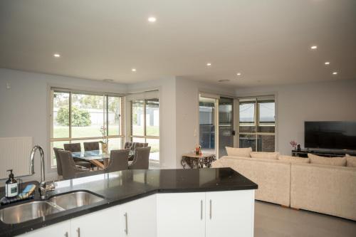 a kitchen and living room with a couch at Alaaya in Wallan