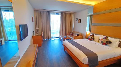 a hotel room with a bed and a television at Mountain Retreat Kodai in Kodaikānāl