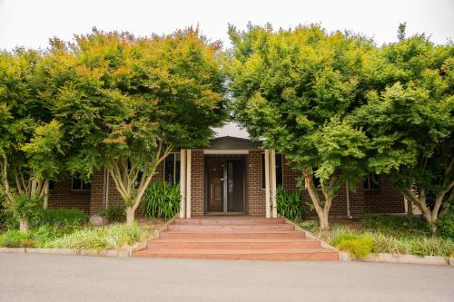 a brick house with trees in front of it at Alaaya in Wallan