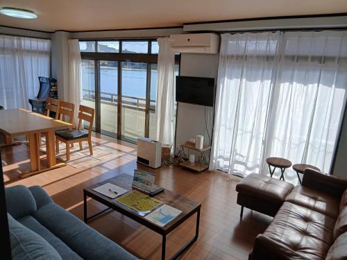 uma sala de estar com um sofá e uma mesa em ゲストハウスMOANa em Hitachinaka