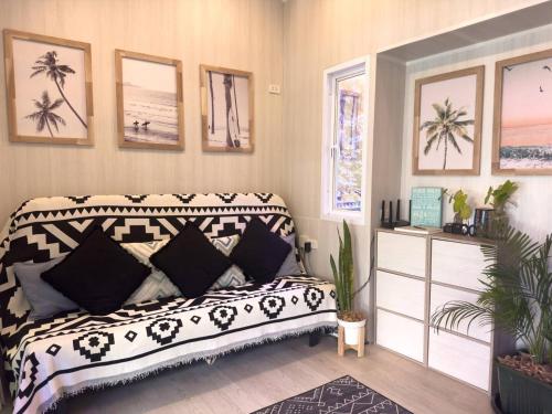 Un dormitorio con una cama con almohadas blancas y negras. en Three Palms - Beach Front Tiny House by SP Villa, en Nathon Bay