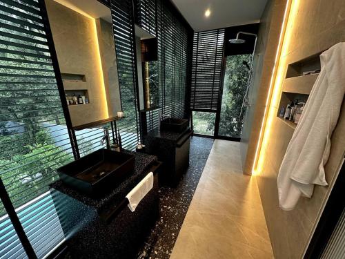 een badkamer met een zwarte wastafel en een raam bij Villa Noor by S&P Villa Management in Ko Phangan