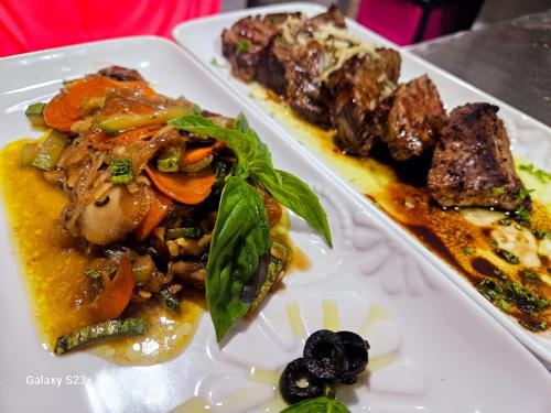 two white plates of food with meat and vegetables at Departamento Pavones Beach Retreat in Pavones