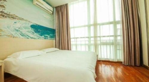 Super 8 Hotel Jinan Railway Station Square في جينان: غرفة نوم بسرير أبيض ونافذة كبيرة