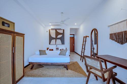 The Green Rooms Surf & Yoga Camp - ON THE BEACH - Prime location Renovated 2024 في يليغاما: غرفة نوم بسرير وسلم ومكتب