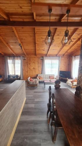 a large room with a wooden ceiling with a table at CASA EN PALAFITO in El Quisco