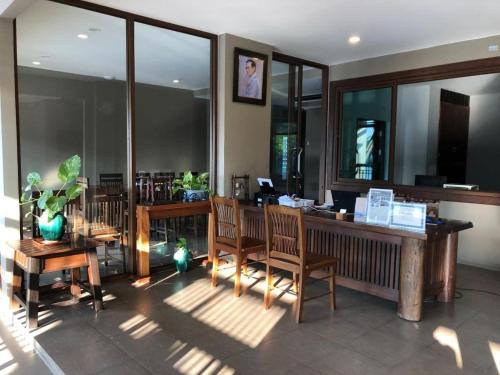 a restaurant with wooden tables and chairs and windows at Pawa Place (By Inpawa) in Ban Phai