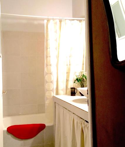 a bathroom with a red ottoman next to a tub at Casa Buika in Tilcara