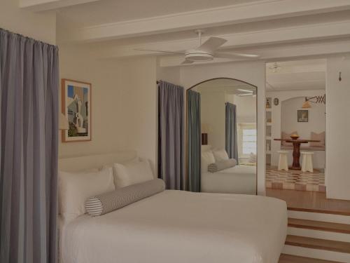 een slaapkamer met een wit bed en een spiegel bij Il Delfino Seaside Inn in Yamba