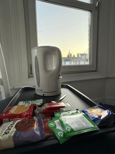 a table with a toaster and some food and a window at Swanvale Lodge Hotel in Great Yarmouth