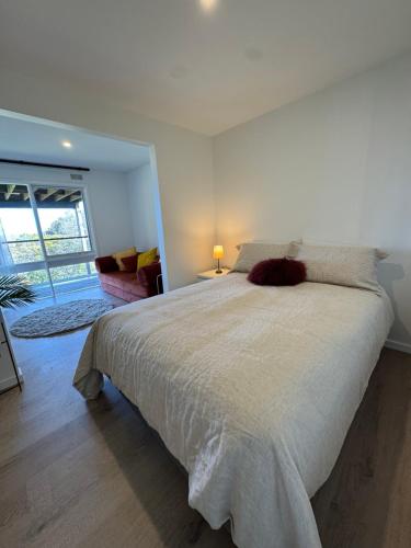 a bedroom with a large bed with a large window at Jalpari in McCrae