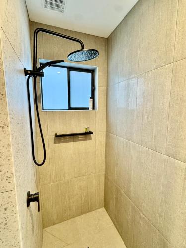 a bathroom with a shower with a window and a shower head at Jalpari in McCrae